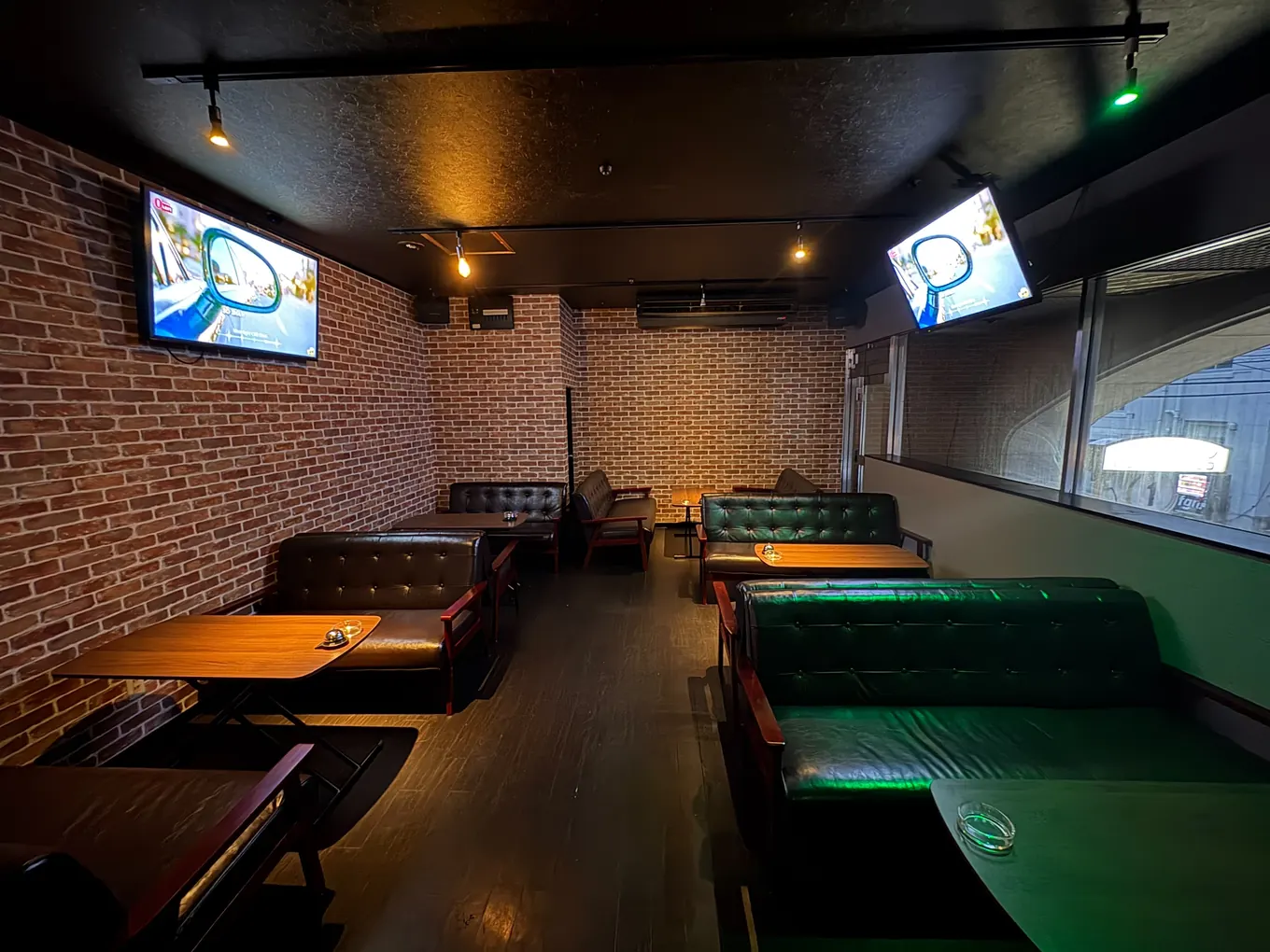 BAR Road のソファ席。レンガの壁沿いに革張りのソファとテーブルが並んでいる